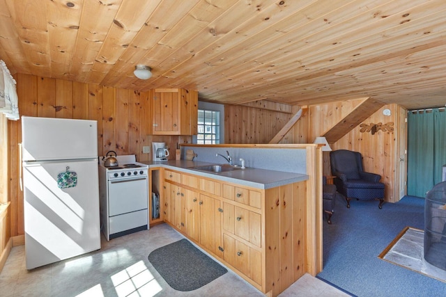 kitchen featuring light brown cabinetry, sink, white appliances, wooden ceiling, and wood walls