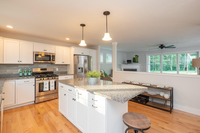 kitchen featuring white cabinets, ceiling fan, appliances with stainless steel finishes, and light hardwood / wood-style flooring