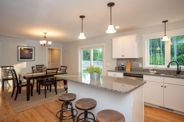 kitchen featuring a chandelier, decorative light fixtures, light wood-type flooring, and sink