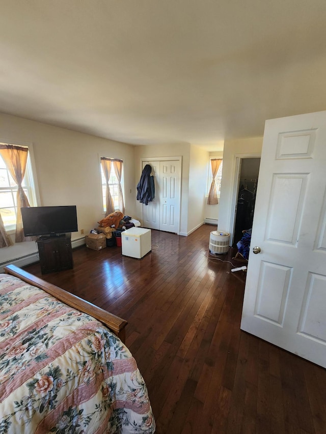 bedroom with dark wood-type flooring and a baseboard radiator