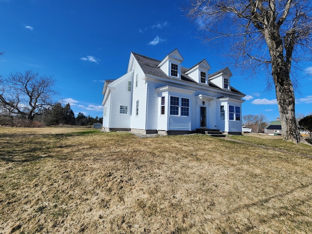 cape cod-style house featuring a front yard