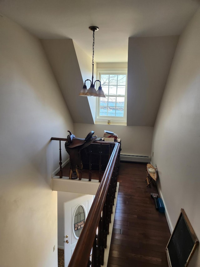 stairway featuring lofted ceiling, baseboard heating, a chandelier, and hardwood / wood-style flooring