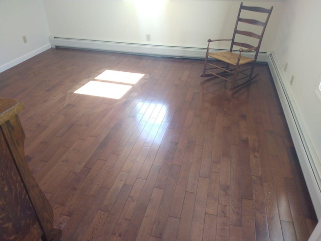 spare room with a baseboard radiator and dark hardwood / wood-style floors