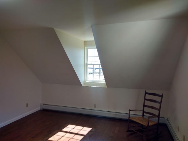 additional living space with a baseboard heating unit, dark hardwood / wood-style flooring, and lofted ceiling