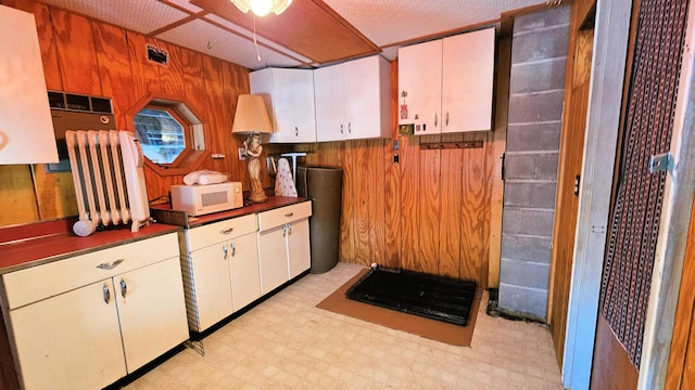 kitchen with white cabinets and wood walls