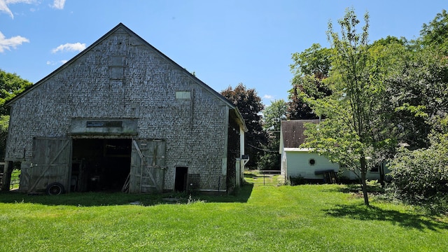 view of side of property featuring an outdoor structure and a lawn