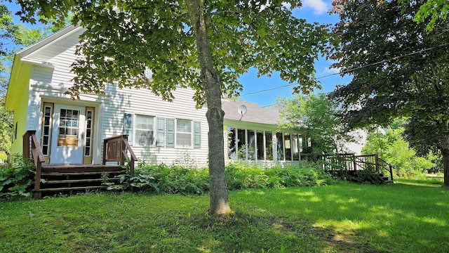 rear view of property featuring a lawn