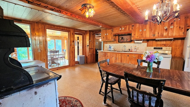 kitchen featuring sink, white electric stove, kitchen peninsula, beamed ceiling, and wood walls