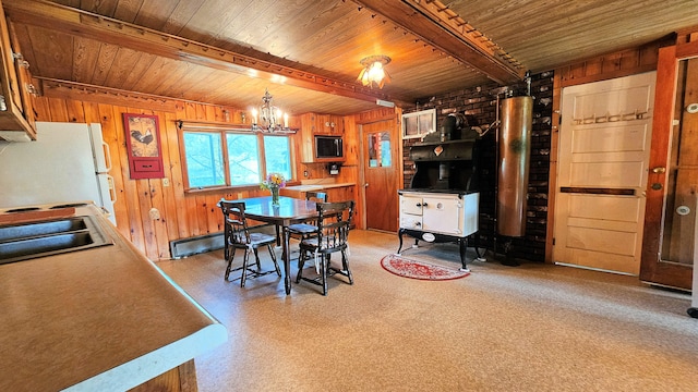 dining area with sink, a chandelier, a baseboard heating unit, wooden ceiling, and beam ceiling