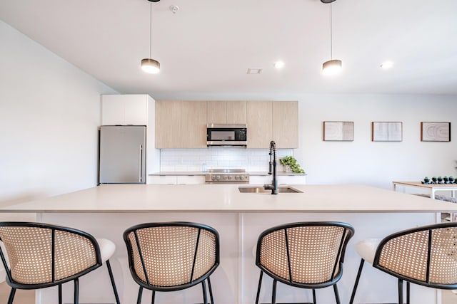 kitchen with pendant lighting, backsplash, stainless steel appliances, and sink