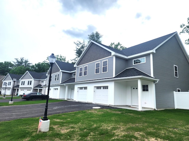 back of property with a garage and a lawn