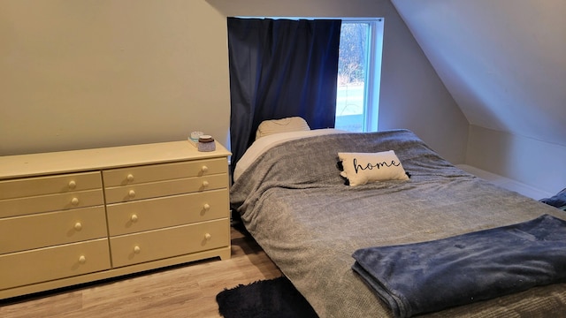 bedroom with light hardwood / wood-style flooring and vaulted ceiling