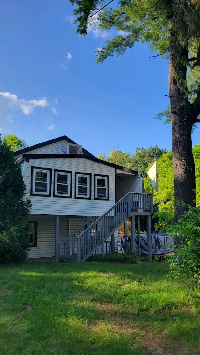 view of front of property featuring a front lawn and a wooden deck