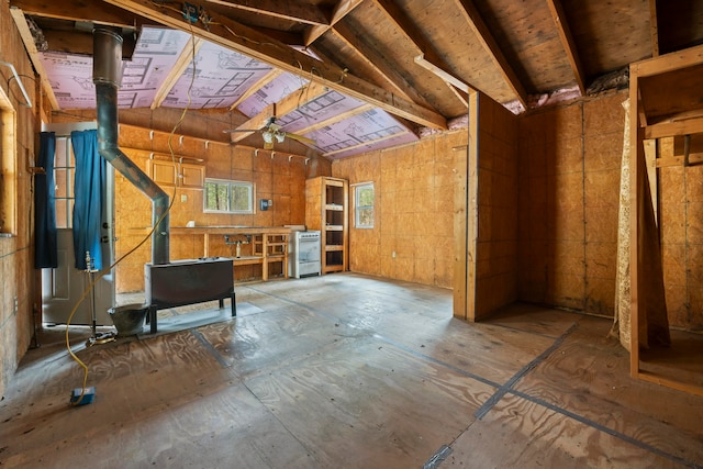 interior space with lofted ceiling, a wood stove, and ceiling fan