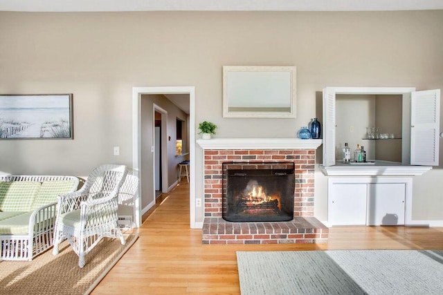 living room featuring hardwood / wood-style floors and a brick fireplace