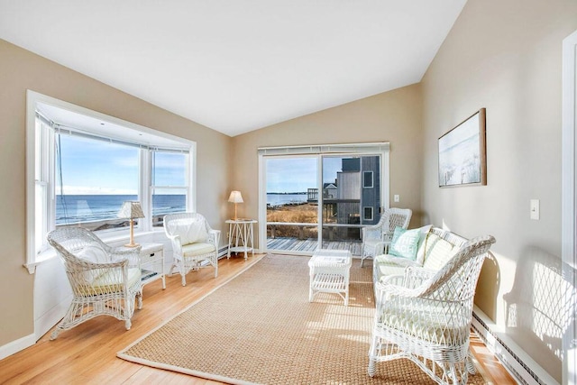 sitting room with hardwood / wood-style floors, a water view, a baseboard radiator, and lofted ceiling