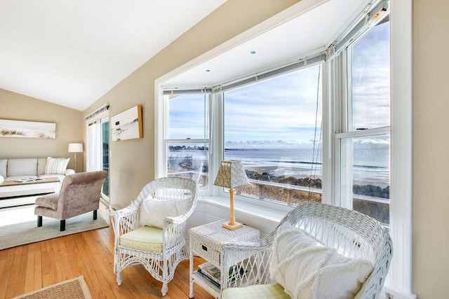 living room featuring a water view, vaulted ceiling, and light hardwood / wood-style floors