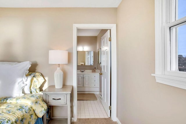 bedroom featuring light carpet and ensuite bathroom