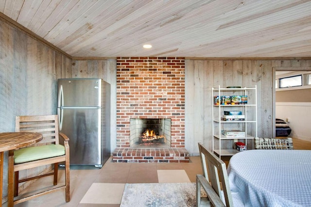 dining space featuring wooden ceiling, a fireplace, and wooden walls