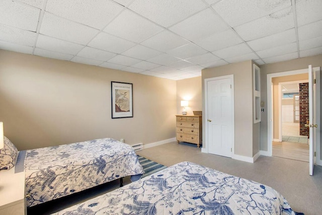 bedroom with a paneled ceiling and a baseboard radiator