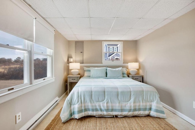 tiled bedroom featuring a paneled ceiling and baseboard heating