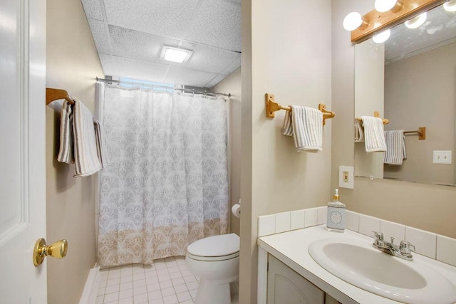 bathroom with curtained shower, tile patterned flooring, toilet, a paneled ceiling, and vanity