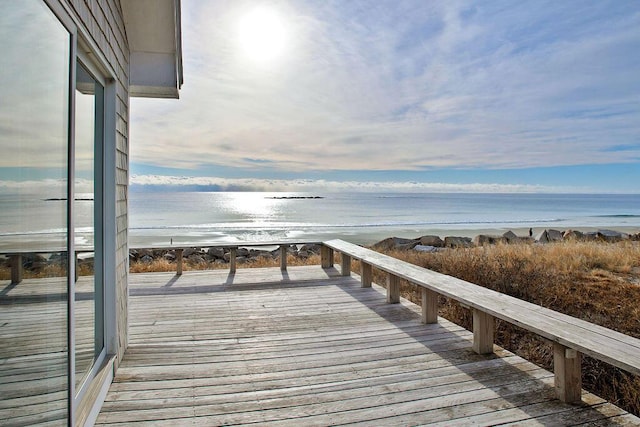 dock area featuring a water view and a beach view