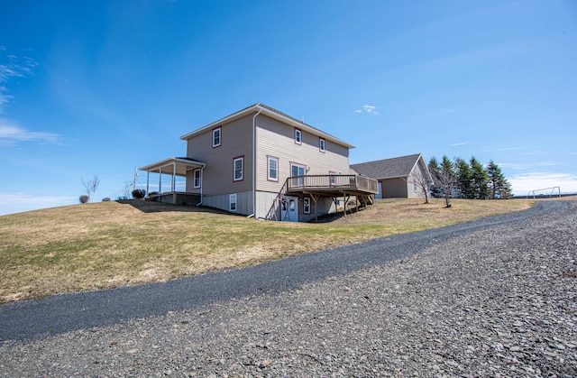 exterior space featuring a wooden deck and a lawn