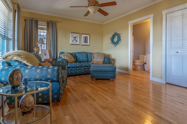 living room featuring ceiling fan, ornamental molding, and hardwood / wood-style floors