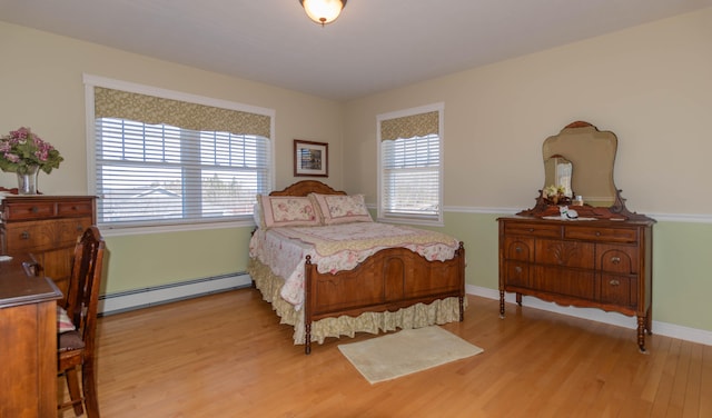 bedroom featuring baseboard heating and light hardwood / wood-style flooring