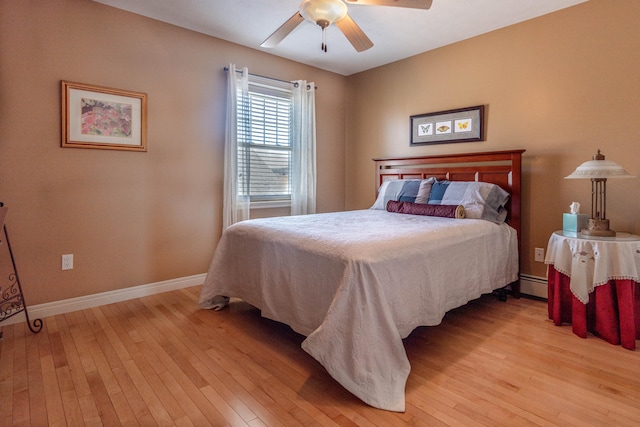 bedroom featuring ceiling fan, a baseboard radiator, and light hardwood / wood-style floors