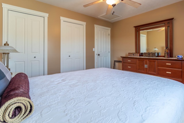 bedroom featuring ceiling fan and multiple closets