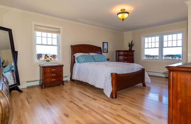 bedroom featuring a baseboard heating unit, light hardwood / wood-style floors, and multiple windows