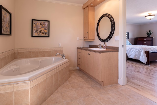 bathroom with vanity, tile patterned floors, ornamental molding, and tiled tub