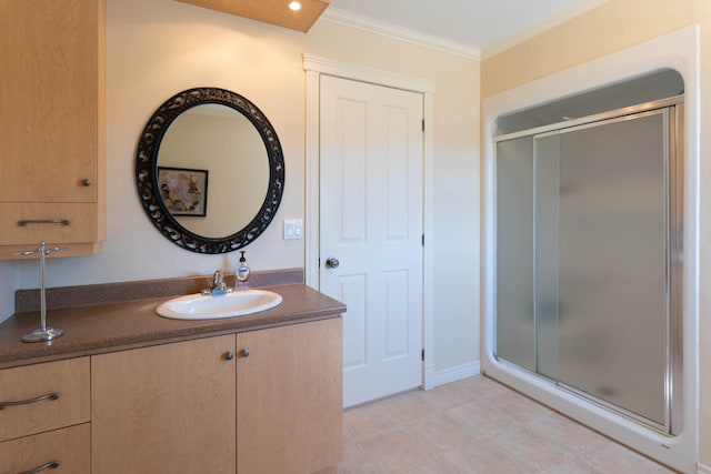 bathroom with a shower with shower door, vanity, ornamental molding, and tile patterned flooring