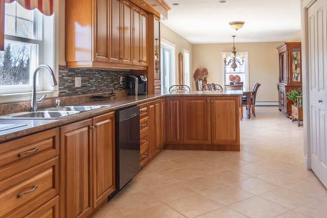 kitchen featuring an inviting chandelier, kitchen peninsula, dishwasher, pendant lighting, and sink