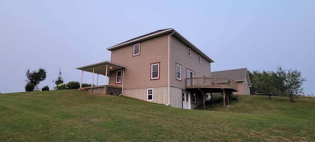 rear view of house with a wooden deck and a yard