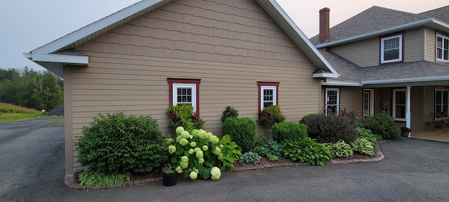 149 Bellevue St, Madawaska, ME 04756 - view of home's exterior with a shingled roof and a chimney