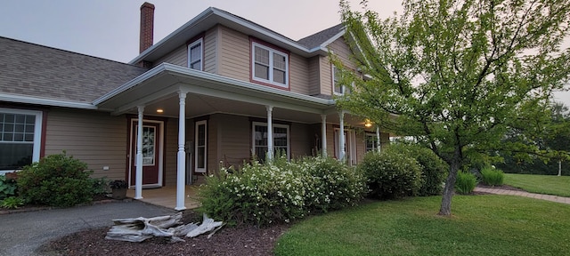 149 Bellevue St, Madawaska, ME 04756 - view of front of home featuring covered porch, a front lawn, a chimney, and roof with shingles