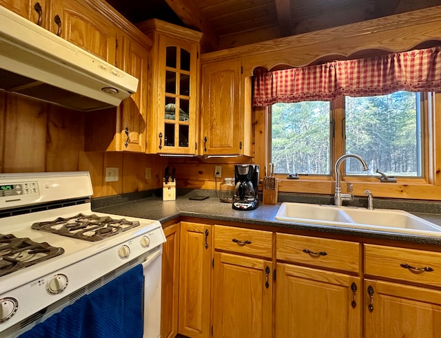 kitchen with vaulted ceiling with beams, wooden ceiling, sink, and white range with gas cooktop