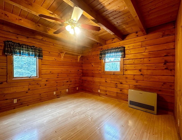 unfurnished bedroom with wooden walls, light wood-type flooring, beam ceiling, and multiple windows