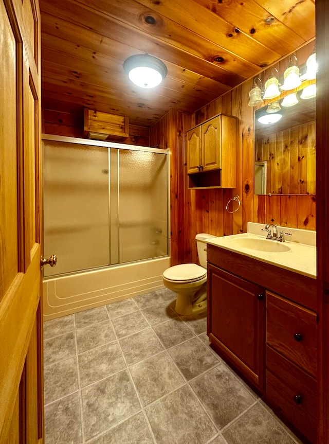 full bathroom featuring wooden walls, vanity, enclosed tub / shower combo, wooden ceiling, and toilet