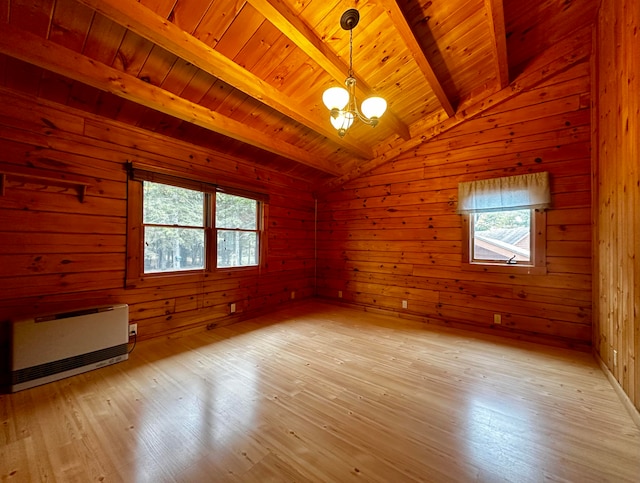 spare room featuring a notable chandelier, light wood-type flooring, wood walls, and wood ceiling