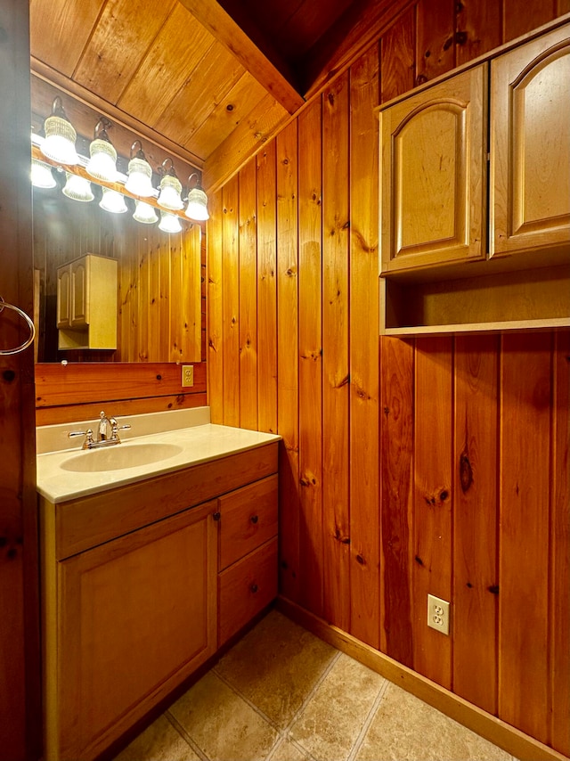 bathroom with vanity, wooden walls, wood ceiling, and tile patterned floors