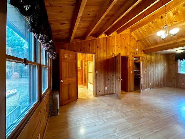 unfurnished room with wooden walls and light wood-type flooring