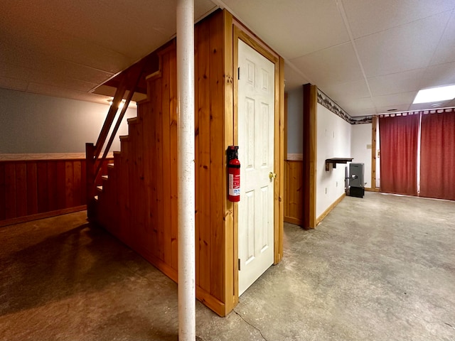 hallway with wood walls and concrete floors