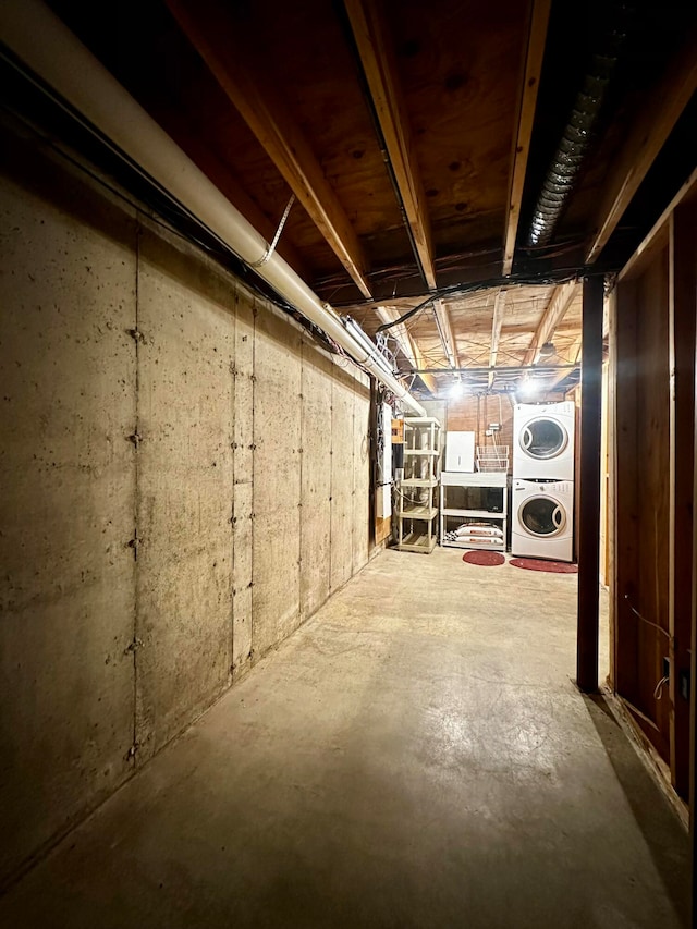 basement featuring stacked washer / dryer