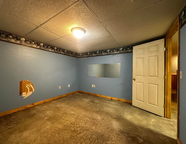 unfurnished room with a paneled ceiling and concrete floors