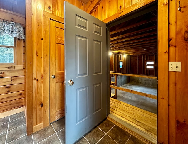 interior space featuring dark tile patterned floors and wood walls