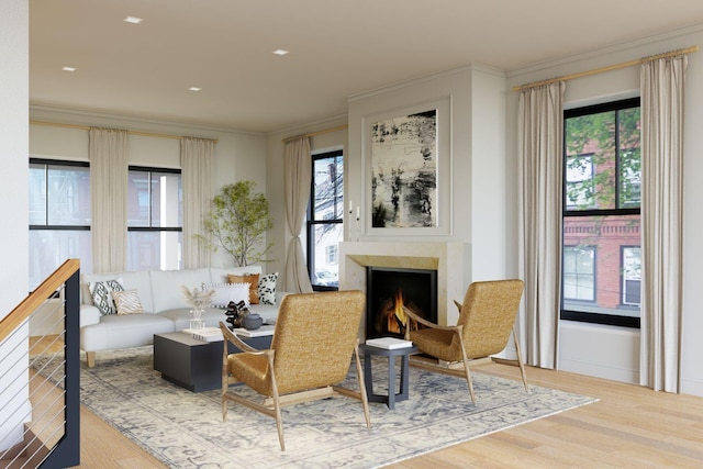 living room with a high end fireplace, hardwood / wood-style flooring, and ornamental molding